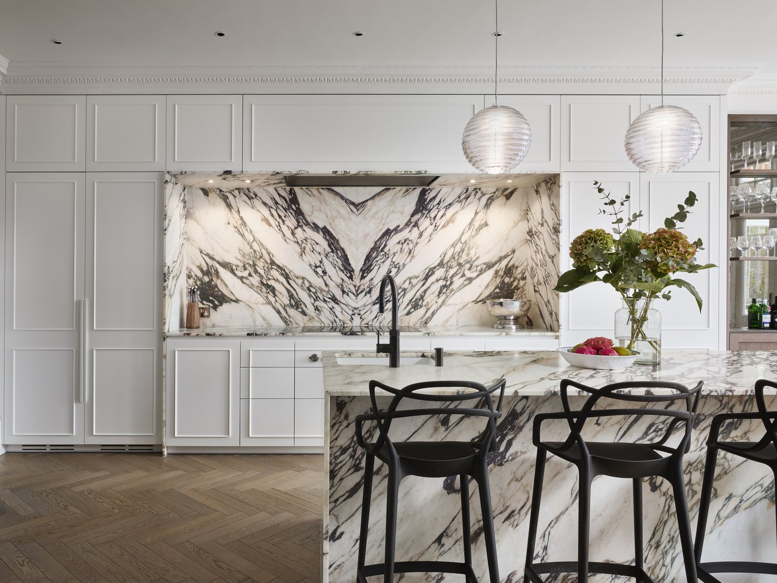 Marble splashback and island with bar seating, framed by full-height painted joinery