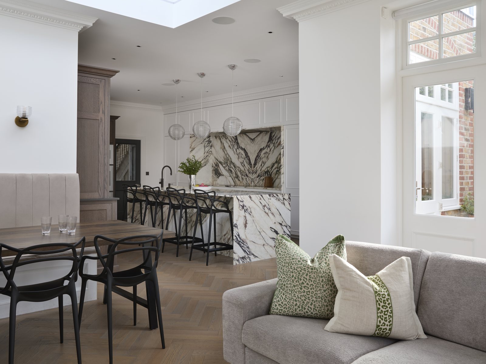 Dining and sitting area opening onto the kitchen, with herringbone flooring and rooflights